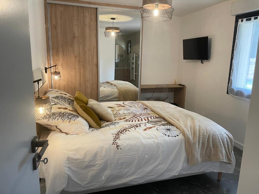 een slaapkamer met twee bedden en een tv aan de muur bij Gîte Domaine d'Hybère in Lucbardez-et-Bargues