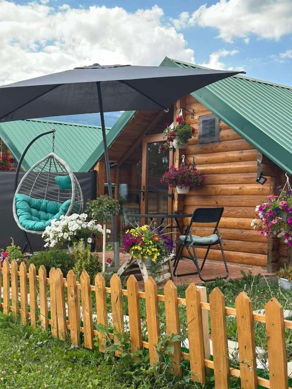 a house with an umbrella and a chair and a swing at Camp Laksi in Plav