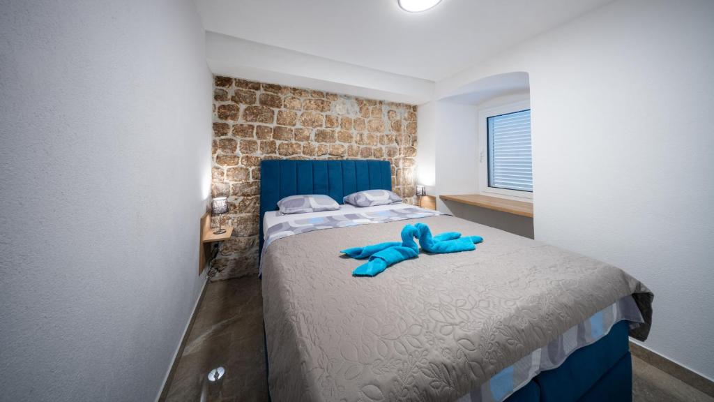 a blue teddy bear sitting on a bed in a room at Apartmani Žunić in Pag
