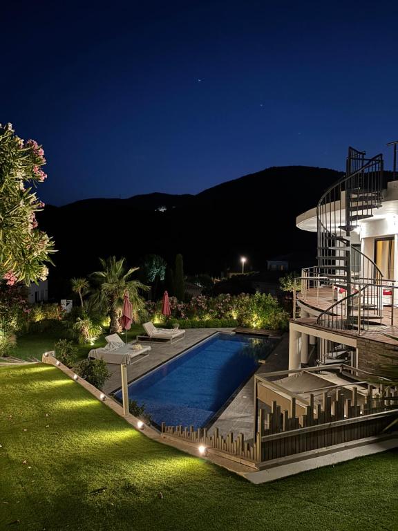 une maison avec piscine la nuit dans l'établissement Grande Villa 350 M2, piscine chauffée vue mer et collines, CAVALAIRE sur mer, 10 personnes, à Cavalaire-sur-Mer