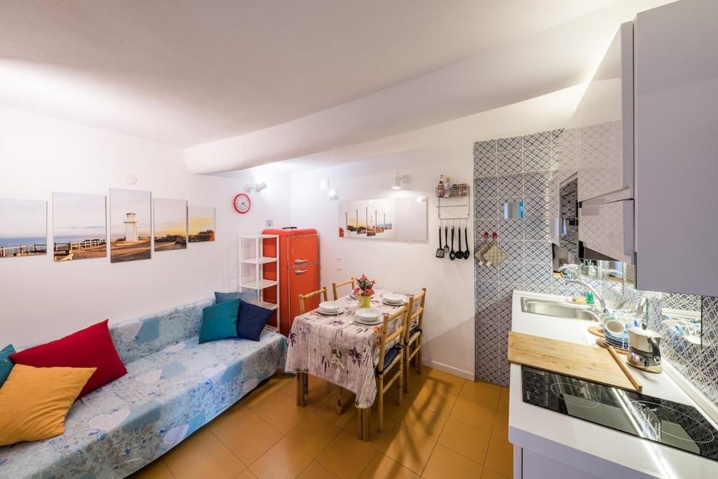 a living room with a couch and a table in a kitchen at 2 minuti a piedi dal mare in Lerici