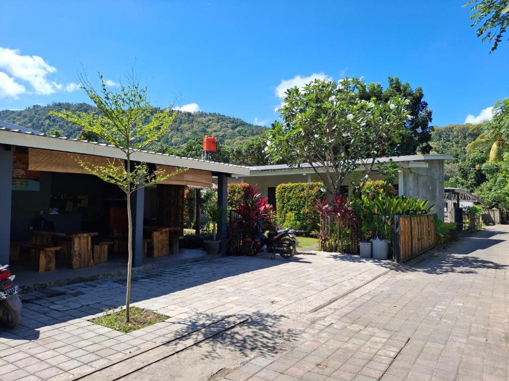 une maison avec un patio avec des arbres et des montagnes en arrière-plan dans l'établissement Sammy Cottage Senggigi, à Mangsit