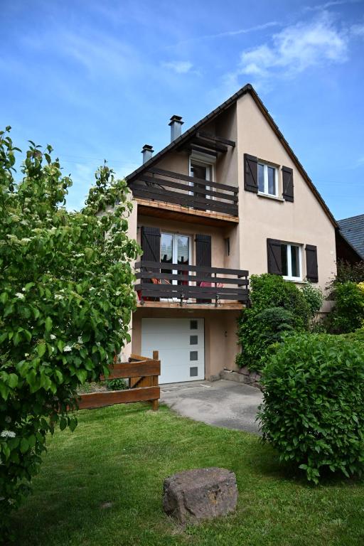 a large house with a balcony and a yard at La Renardière in Labaroche