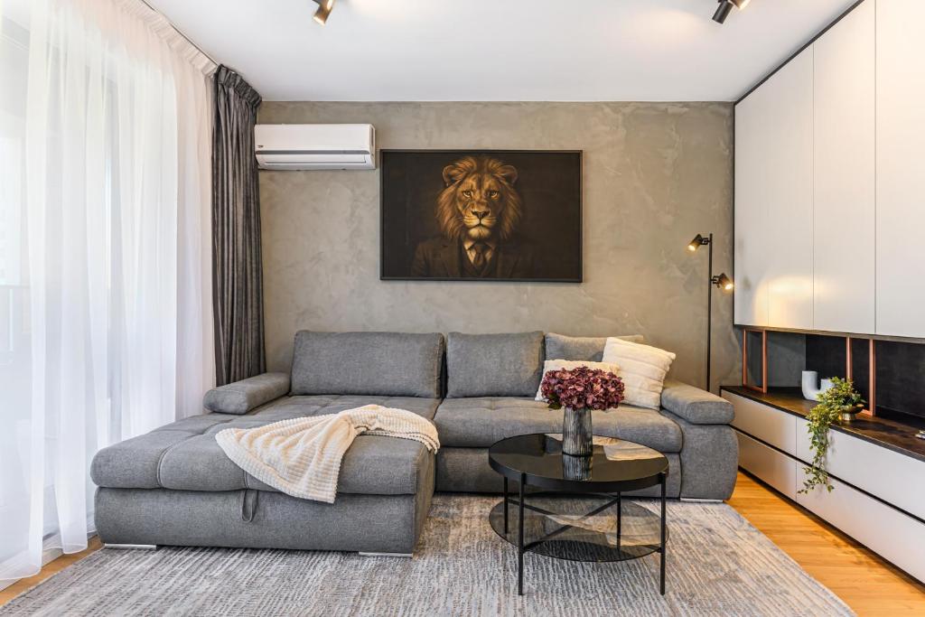 ein Wohnzimmer mit einem Sofa und einem Bild eines Löwen in der Unterkunft KOA - Signature Collection in Braşov