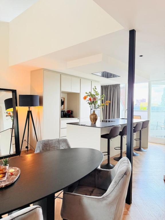 a kitchen and dining room with a table and chairs at Cooth's Luxury Loft with City Views in Breda