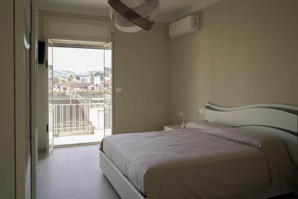 a bedroom with a bed and a large window at La voce del mare in Agropoli