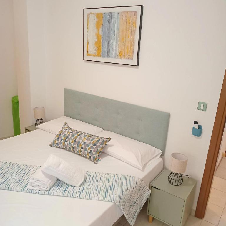 a bed with white sheets and pillows in a bedroom at Hotel Riviera Sanremo in Sanremo