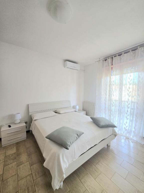 a white bedroom with a bed and a window at AXIS Apartments Terni Essence in Terni