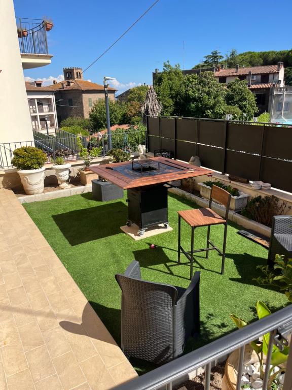 a small backyard with a table and grass at Flaminia guesthouse in Rignano Flaminio