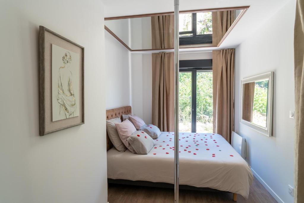 a bedroom with a bed with a glass canopy at Romance Me - Love Room Élégante avec Table de Massage & Pole Dance - Night & Day use in Évreux