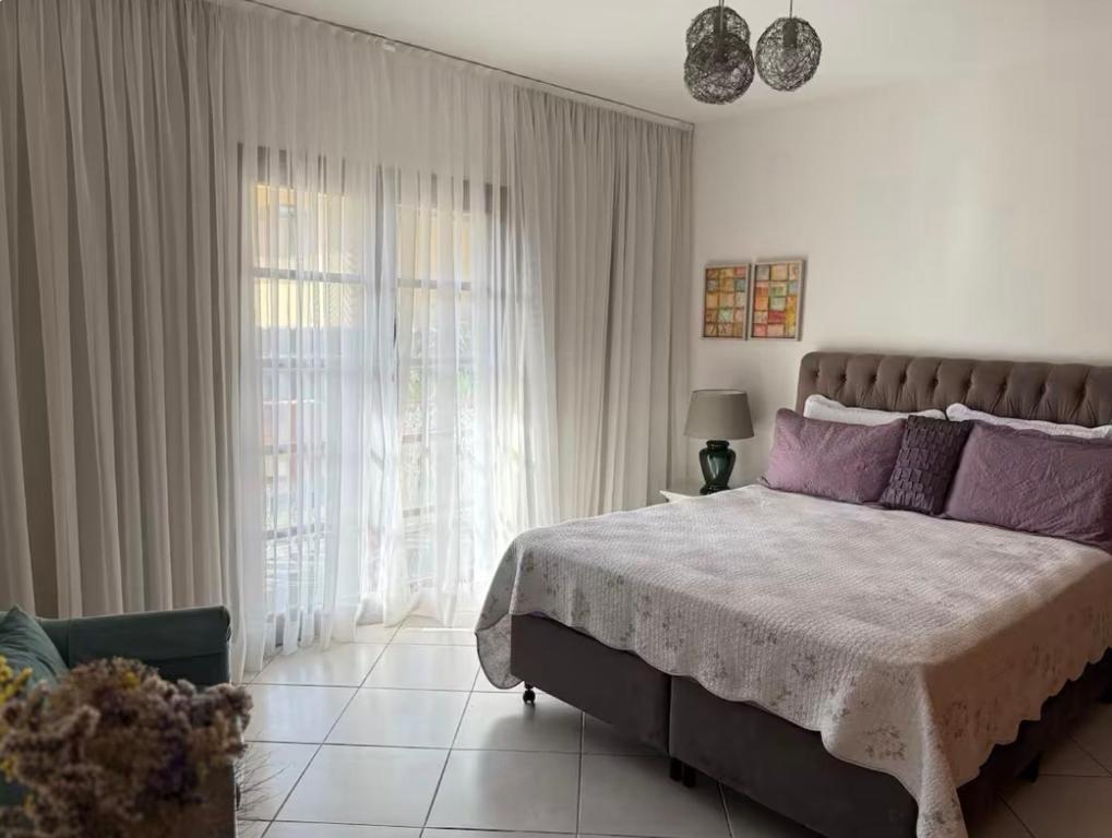 a bedroom with a large bed with purple pillows at Casa Klippel in Petrópolis