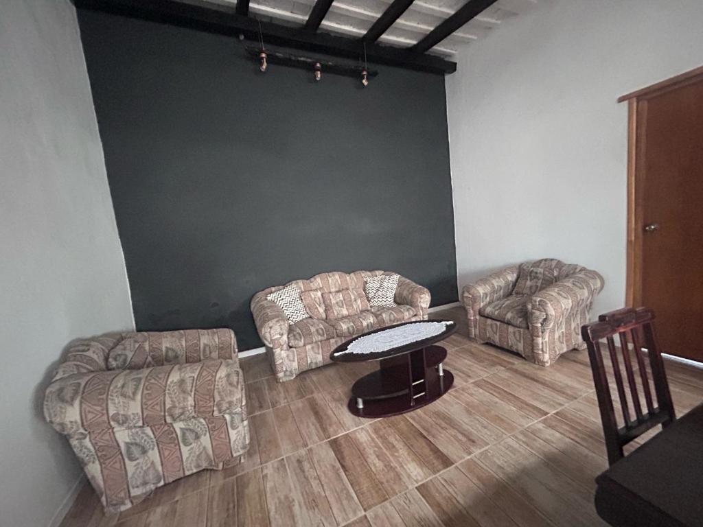 a living room with two couches and a table at Aparthouse-Compartida! in Fray Bentos