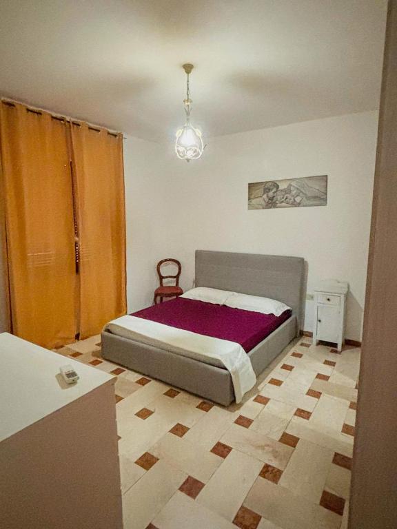 a bedroom with a bed and a chandelier at Villino Emma in Santadi