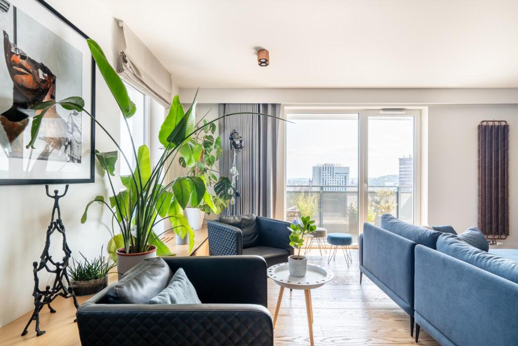 una sala de estar con sofás y plantas azules en Bastion Wałowa by Blue Mandarin, en Gdansk