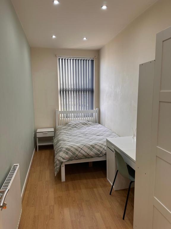 リバプールにあるByrom House Apartmentsのベッドと机と窓のある寝室