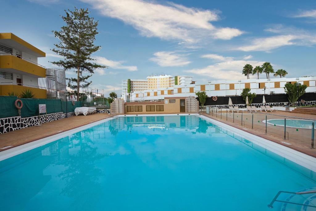 ein großer blauer Swimmingpool vor einem Gebäude in der Unterkunft Luxury Los Cactus in San Bartolomé de Tirajana