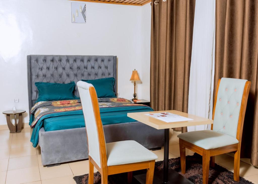a bedroom with a bed and a table and chairs at Hi-Pima Boutique Hotel in Kigali
