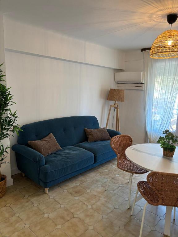 un canapé bleu dans un salon avec une table dans l'établissement Appartement proche stade Vélodrome, à Marseille