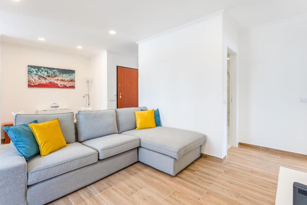 a living room with a gray couch and yellow pillows at Bright 2BDR Flat in Armação de Pêra by LovelyStay in Armação de Pêra