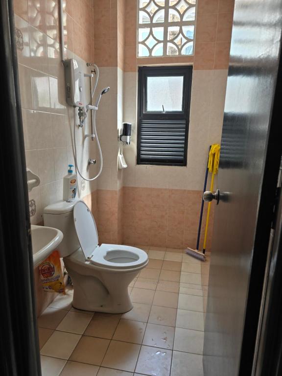 a bathroom with a toilet and a sink and a window at MIA guests house in Nilai