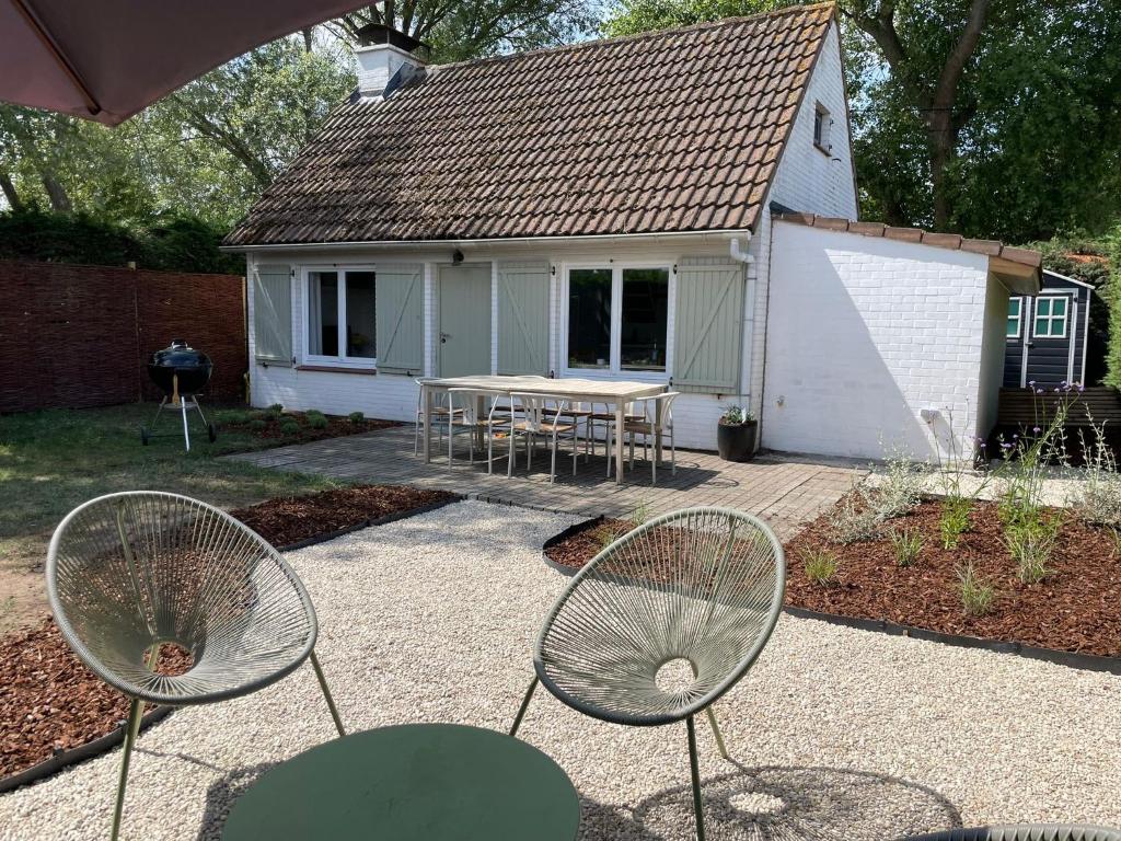 una casa con un tavolo e delle sedie in un cortile di Chocolat & Vanille a Koksijde