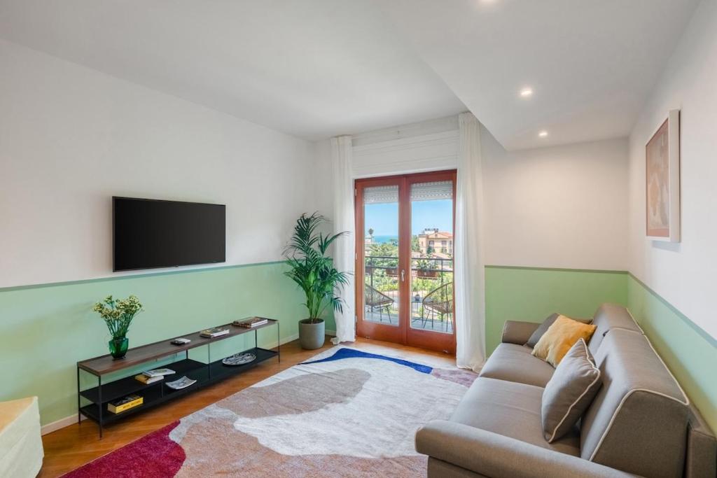 a living room with a couch and a flat screen tv at Sorrento Coast Retreat for Families with Terrace&View in Sant'Agnello