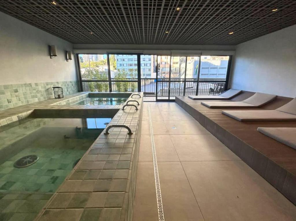 a large room with a pool with benches in it at BHomy Medeiros in Sao Paulo