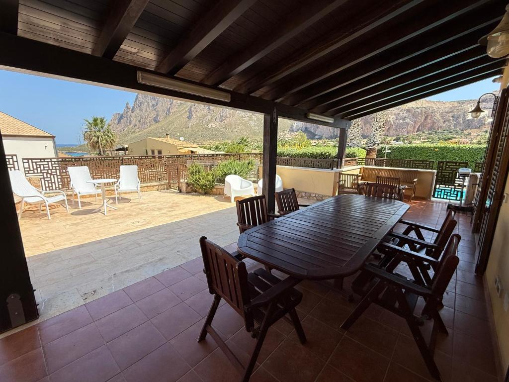 - une table et des chaises en bois sur une terrasse avec vue dans l'établissement Le Case di Palma - Villa Maria, à Custonaci