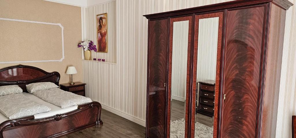 a bedroom with a bed and a large wooden cabinet at Summer in Riga