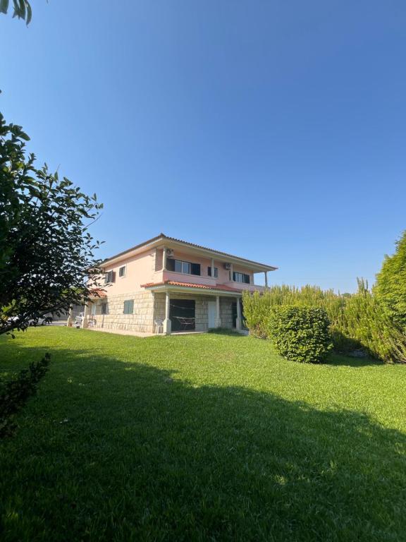 a large house on a grassy field with trees at Casa do Senhor da Ponte in Gondifelos