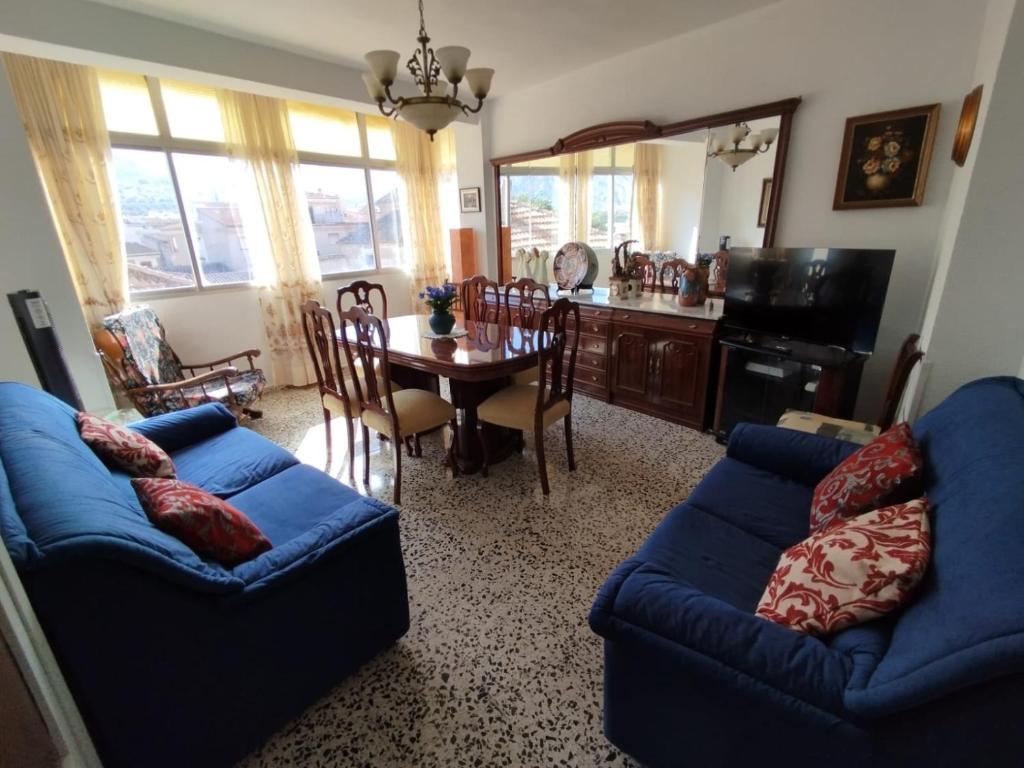 Una sala de estar con un sofá azul y una mesa. en Lorca, en Dúrcal