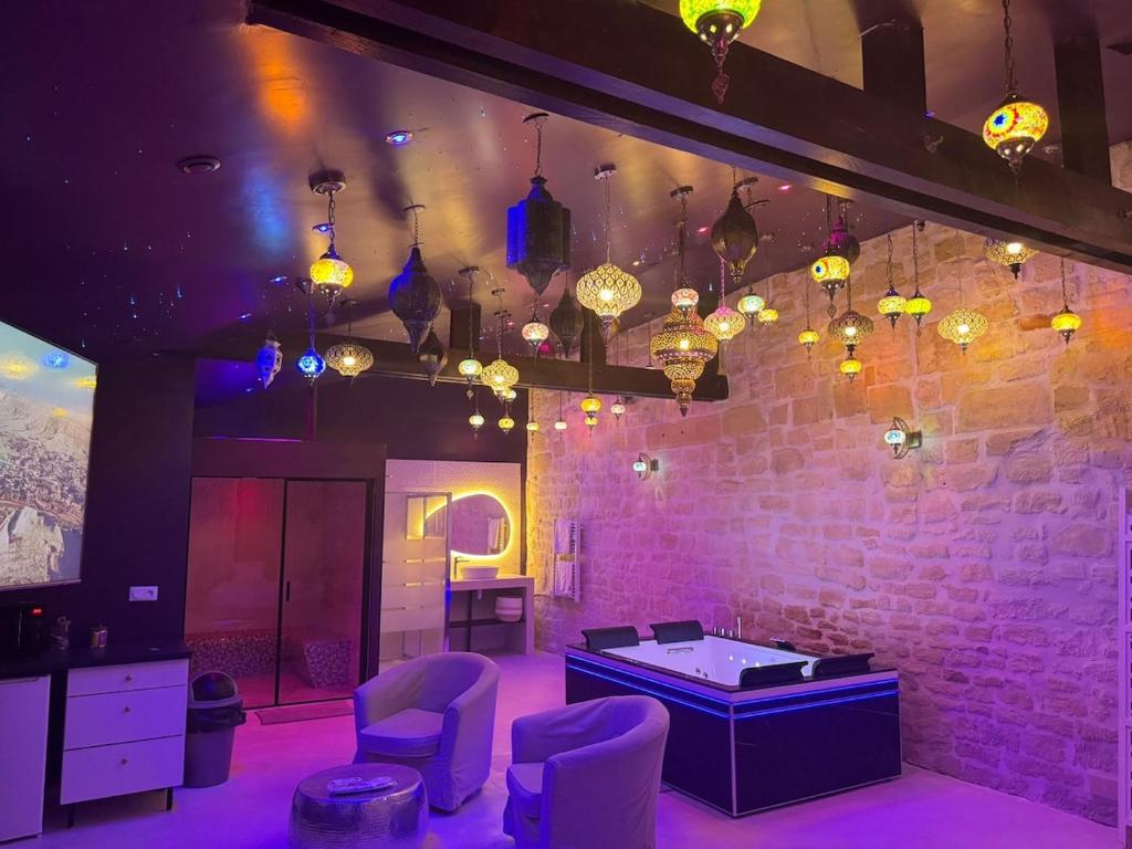a room with a tub and chairs and lights at Appartement Jacuzzi Hammam 1001 Nuits Yaospa60 in Montataire