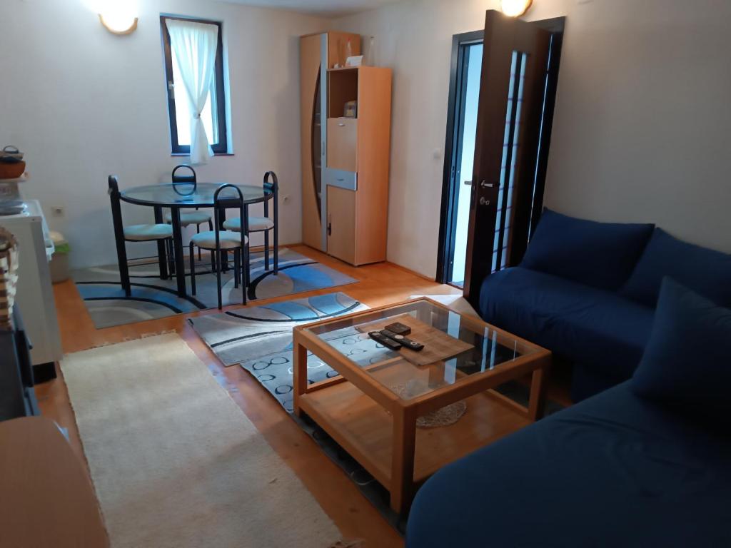 a living room with a blue couch and a table at Vlasic Relax in Vlasic