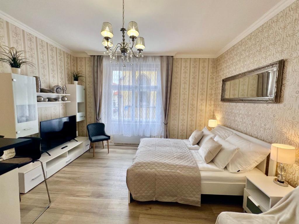 Hotel Romance in the Old Town, a bedroom with a large bed and a chandelier at Romance in the Old Town in Prague