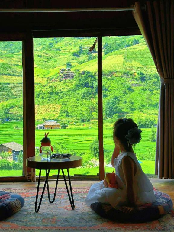 a little girl sitting on the floor in front of a window at Lee Eco House Sapa in Sapa
