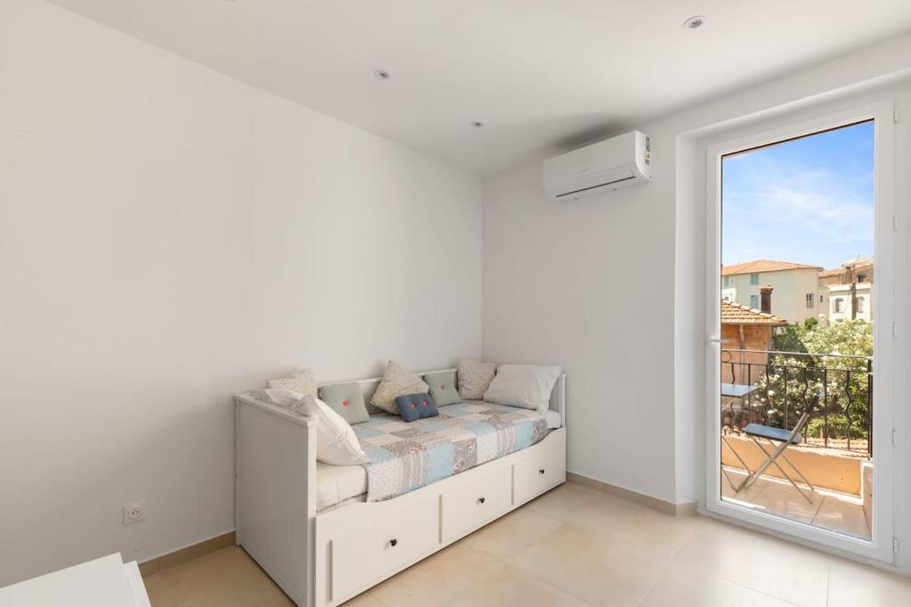 a white room with a couch and a window at La Gravette Coeur du vieil Antibes in Antibes