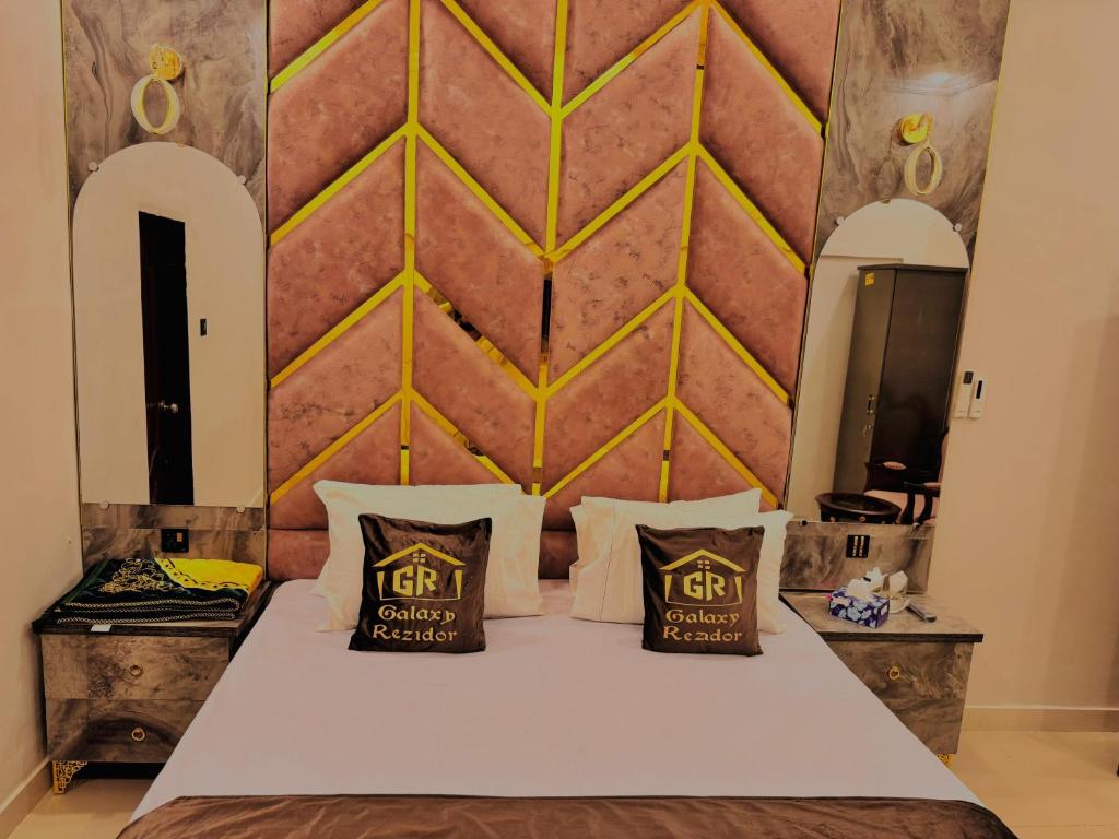a bedroom with a bed with two pillows on it at Galaxy Rezidor in Karachi