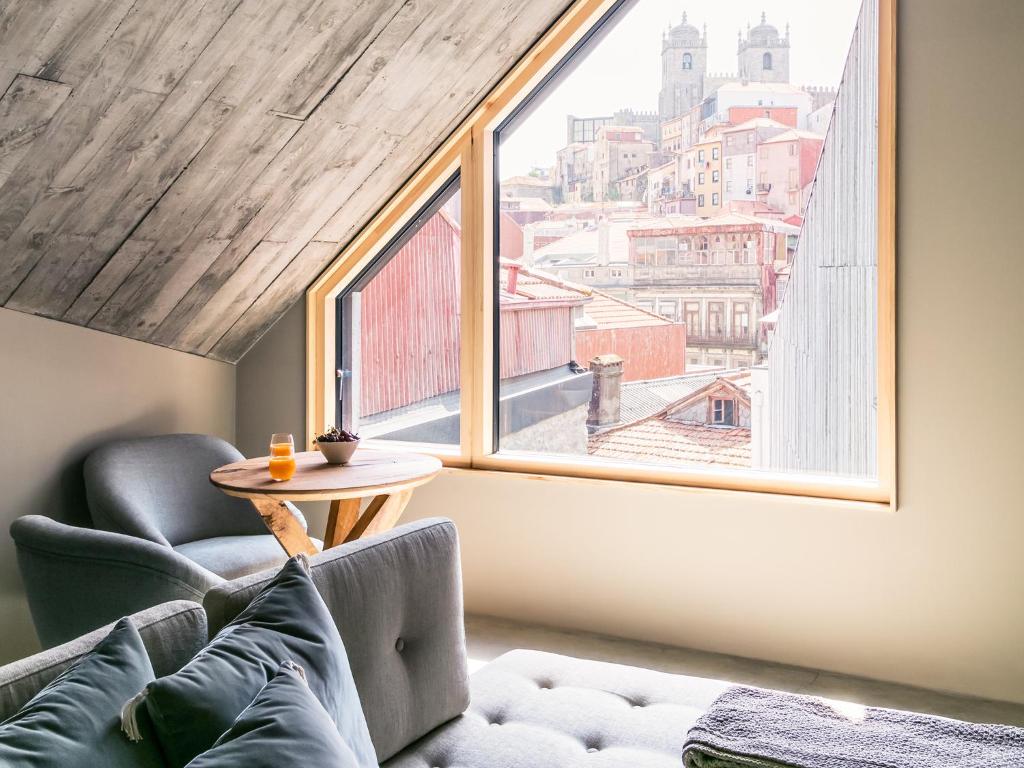 a room with a couch and a table and a large window at Armazém Luxury Housing- Architectural & Design Hotel in Porto