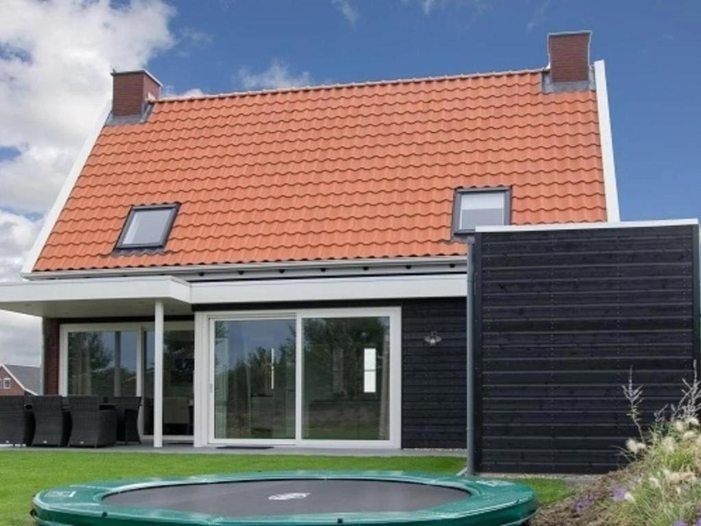 an orange roof on a house with a pool at Coast Calm 71 in Colijnsplaat
