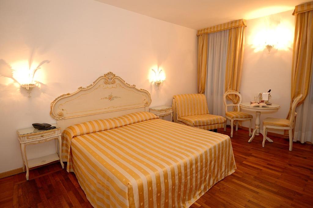 a hotel room with a bed and a table and chairs at Casa Sul Molo in Venice
