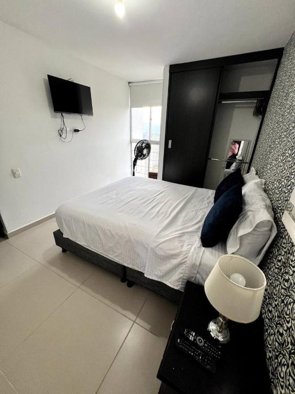 Un dormitorio con una cama grande con una persona en ella. en Descanso y Comodidad en Edificio Seguro con Balcón, en Floridablanca