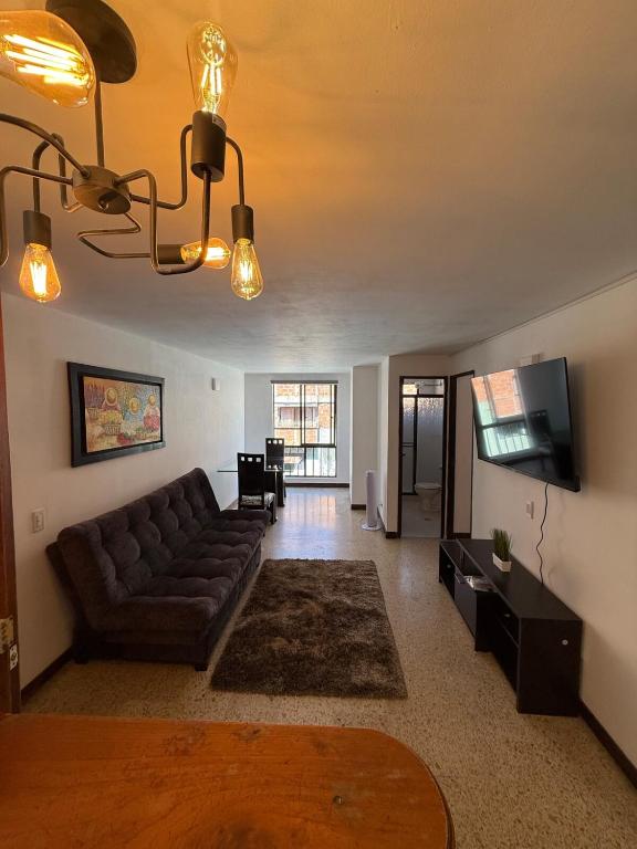uma sala de estar com um sofá e uma TV de tela plana em Apartment 304 em Itagüí
