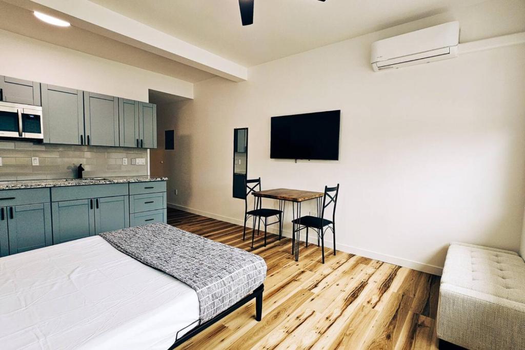 a bedroom with a bed and a kitchen with a table at Unit 1 Waena Inn Newly Renovated Maui Private Suite in Wailuku
