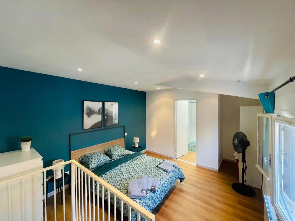een slaapkamer met een bed met een blauwe muur bij Le duplex biterrois in Béziers