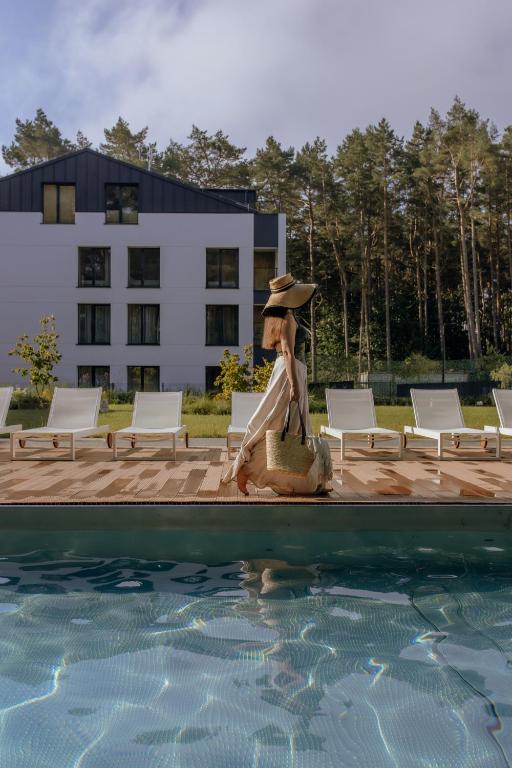 a statue of a woman sitting next to a swimming pool at Sea Shell Apartments Łukęcin in Łukęcin