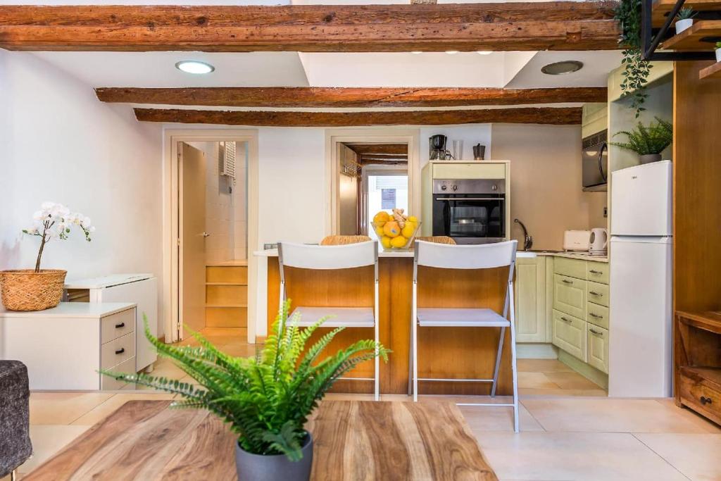 a kitchen with white appliances and wooden beams at Fridays Flats Dreamy Duplex - Stylish Beach Loft in Barcelona
