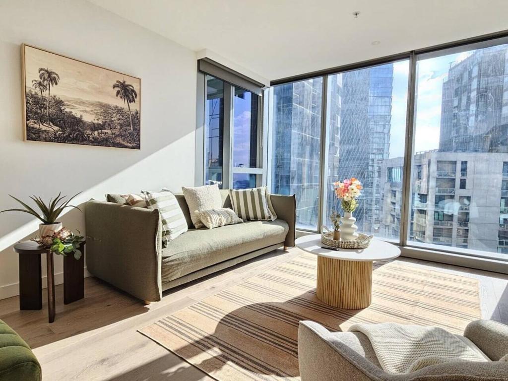 a living room with a couch and a table at Elegant High-End CBD Suite Heated Pool Gym Sauna in Melbourne