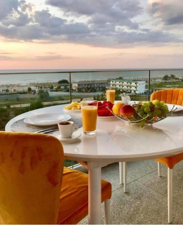 a table with a bowl of fruit on top of a balcony at Apartament Lux Eika in Mamaia Sat/Năvodari