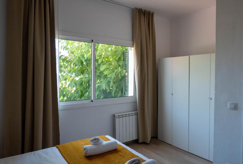 a bedroom with a bed and a large window at Casa Vella de Casa Torrent in Canet de Mar