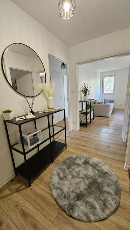 a living room with a mirror and a rug at Les Reflets de Dijon in Dijon